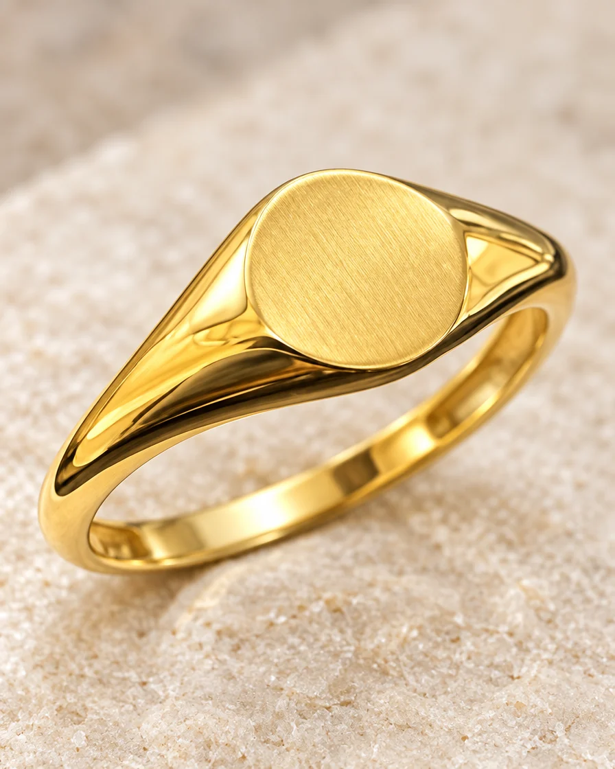 Macro of the brushed oval face and polished shoulders of the 18K gold signet ring