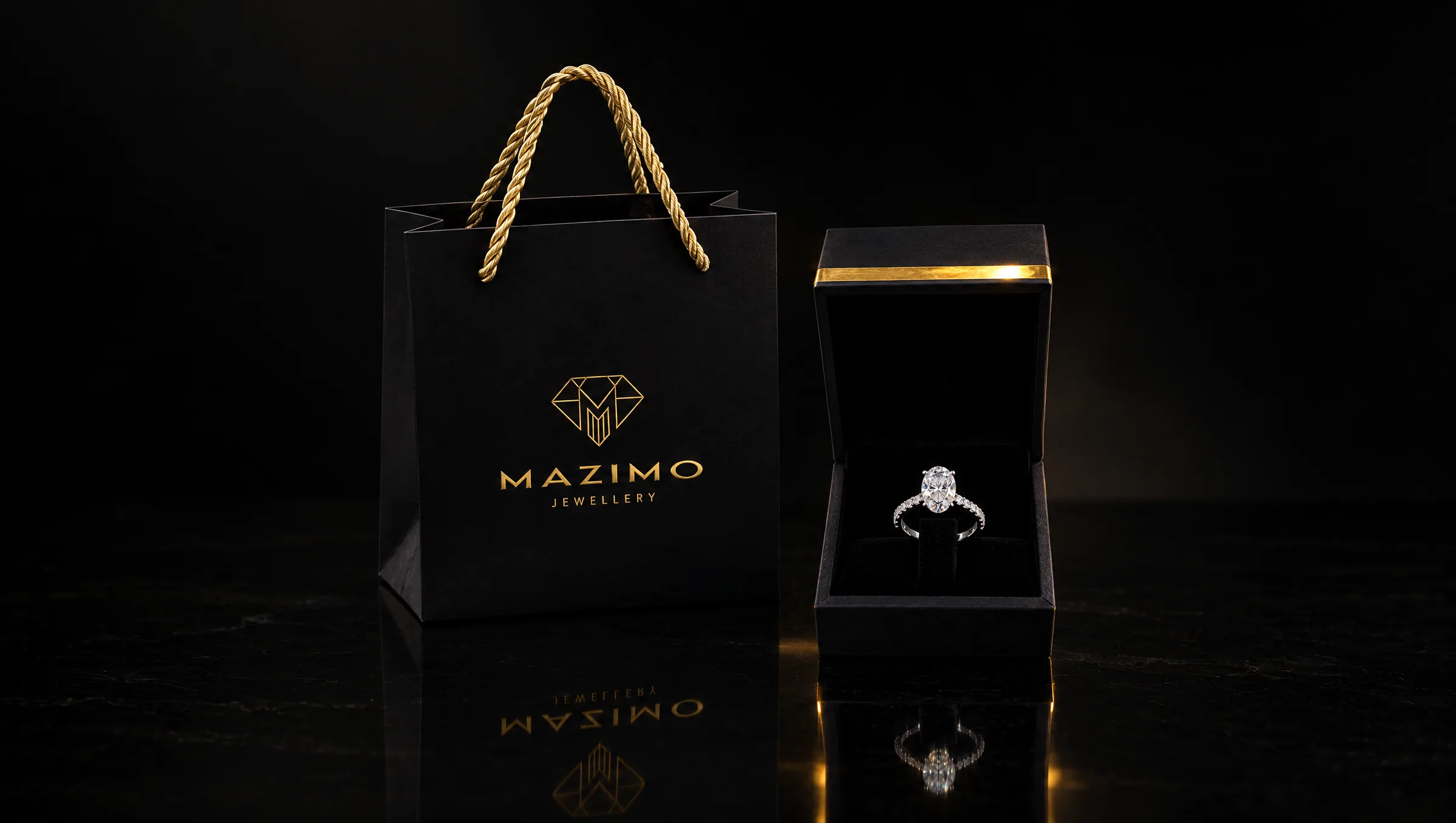 The black Mazimo gift bag beside an open ring box holding an oval diamond ring, on a black polished surface