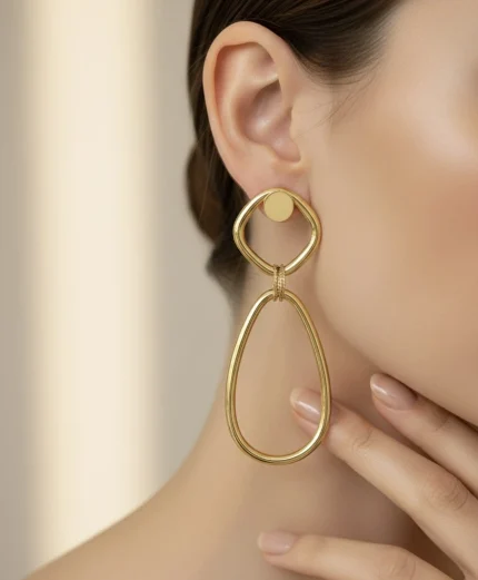 18K gold geometric drop earrings worn on ear, featuring a modern open oval design with a polished Italian finish, weighing 9.80 grams.