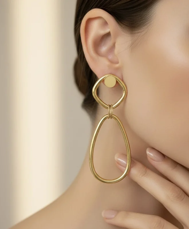 18K gold geometric drop earrings worn on ear, featuring a modern open oval design with a polished Italian finish, weighing 9.80 grams.