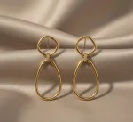 18K gold geometric drop earrings worn on ear, featuring a modern open oval design with a polished Italian finish, weighing 9.80 grams.