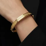 18K gold Mazimo Greek key engraved bangle bracelet with polished finish, 8.10 grams