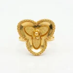 21K gold flower design ring with textured details on a model hand and white background