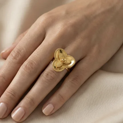 21K gold flower design ring with textured details on a model hand and white background